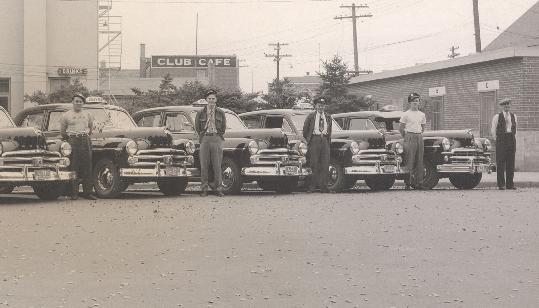 Men standing next to cars, ca. 1950s