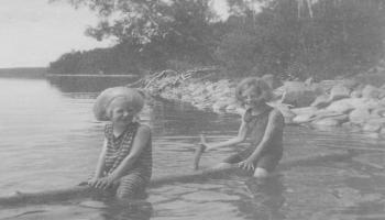 Red Deer Archives, P5687; Two girls on a log on Sylvan Lake, ca. 1920