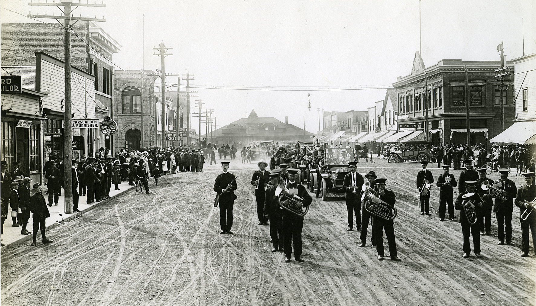 Black and white photo of a marching band in the middle of Ross Street, Red Deer, in1912