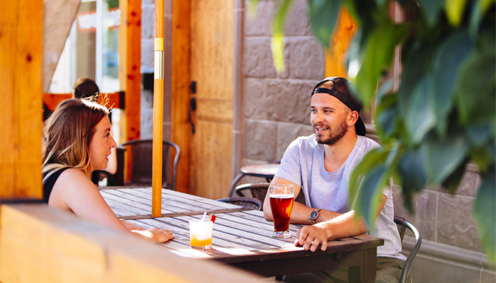 Couple enjoying a beverage on a patio on a hot summer day in downtown Red Deer, Alberta