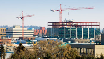 Photo of two construction cranes building in downtown Red Deer