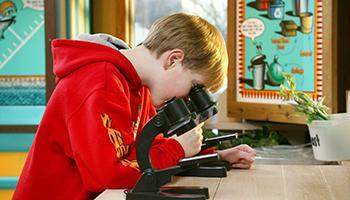 Child with microscope on Waste Management Facility Tour