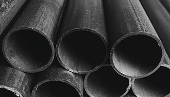 picture of black pipes stacked up in a pile