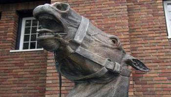 Close up of the horses head of the bronze sculpture of a horse-drawn wagon used by the fire brigade.