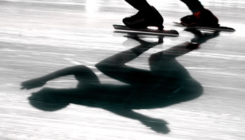 Photo of speed skater's skates and the shadow of the skater